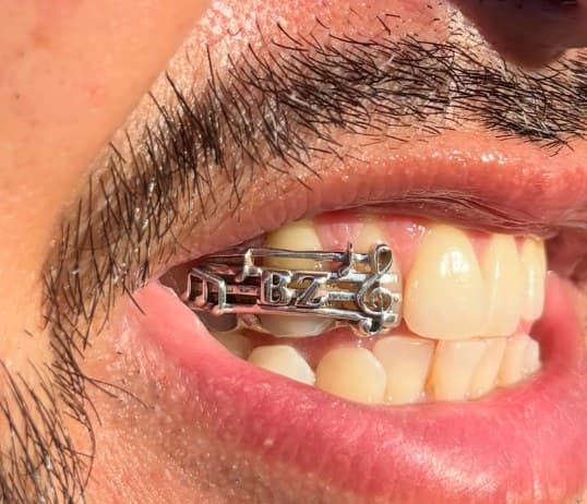 Silver grill with music notes, a treble clef and initials
